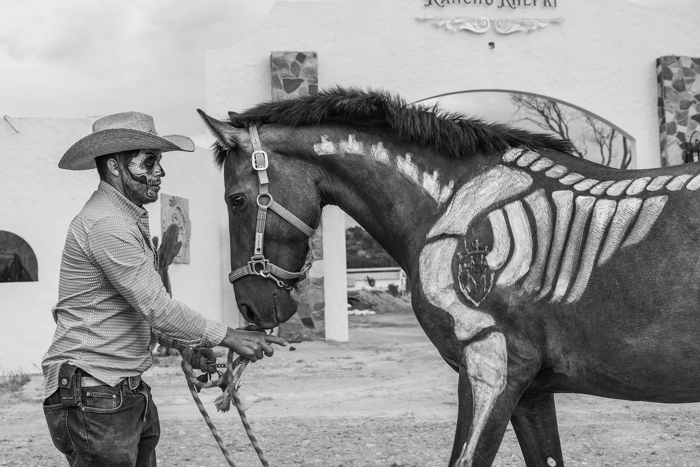 Cowboy leading a horse painted for Día de los Muertos